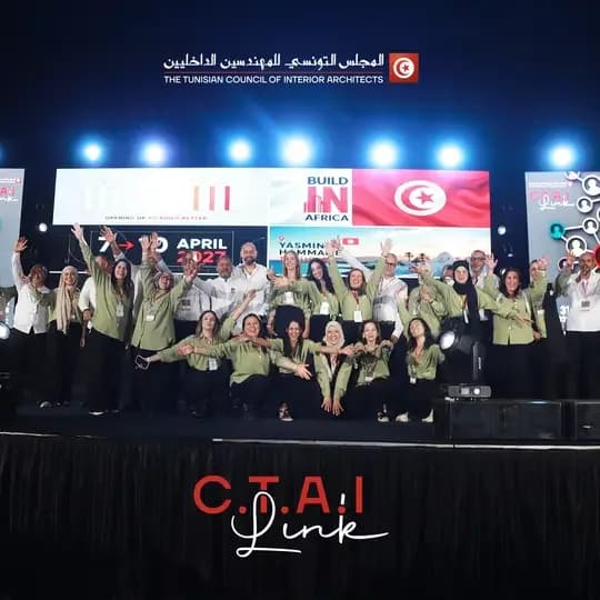 A group, most in olive-green shirts, on stage with arms raised, in front of LED screens showing Build in Africa, the dates 7–10 April 2027 and Yasmine Hammamet; “C.T.A.I Link” at the bottom of the image