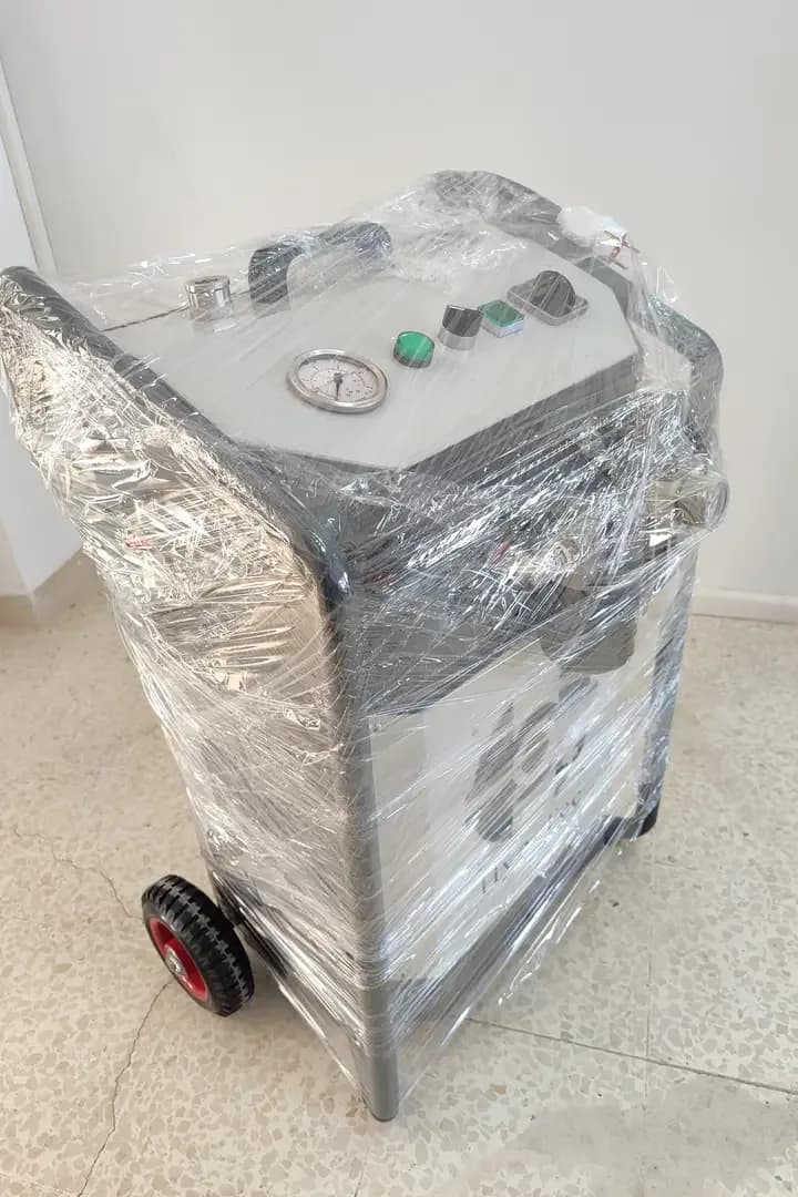 Photo from the delivery announcement: a HyO-Gen1000 machine wrapped in plastic film, with a grey wheeled frame and a control panel with a pressure gauge, a green indicator light and buttons